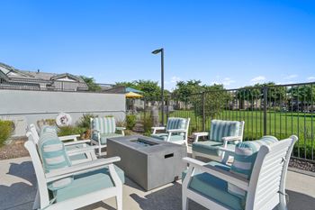 furnished patio with blue and white chairs and a firepit
